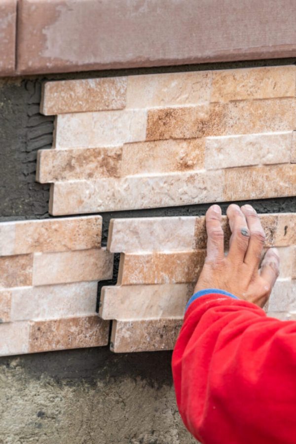 Worker Installing Wall Tile at Construction Site.